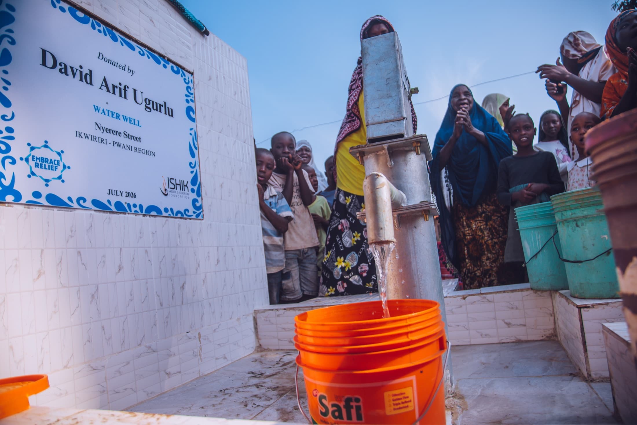 Community members gathered around a completed Embrace Relief water well