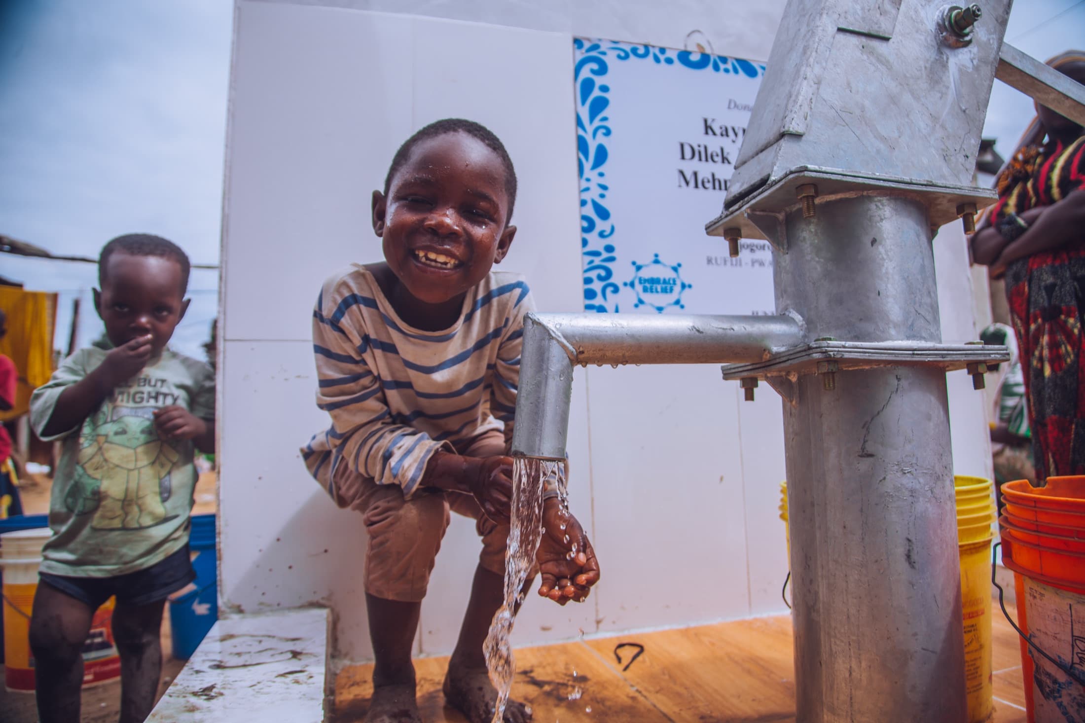 Child using a completed Embrace Relief water well