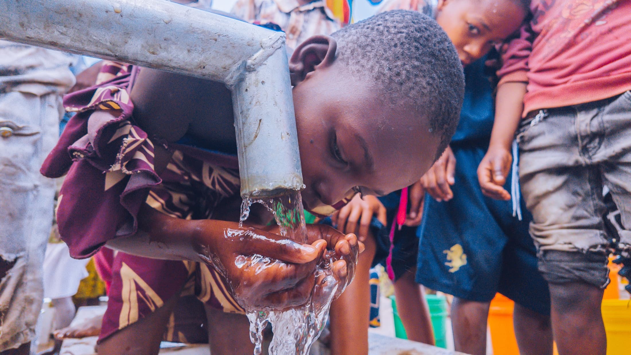 Children gathering around a completed community water well