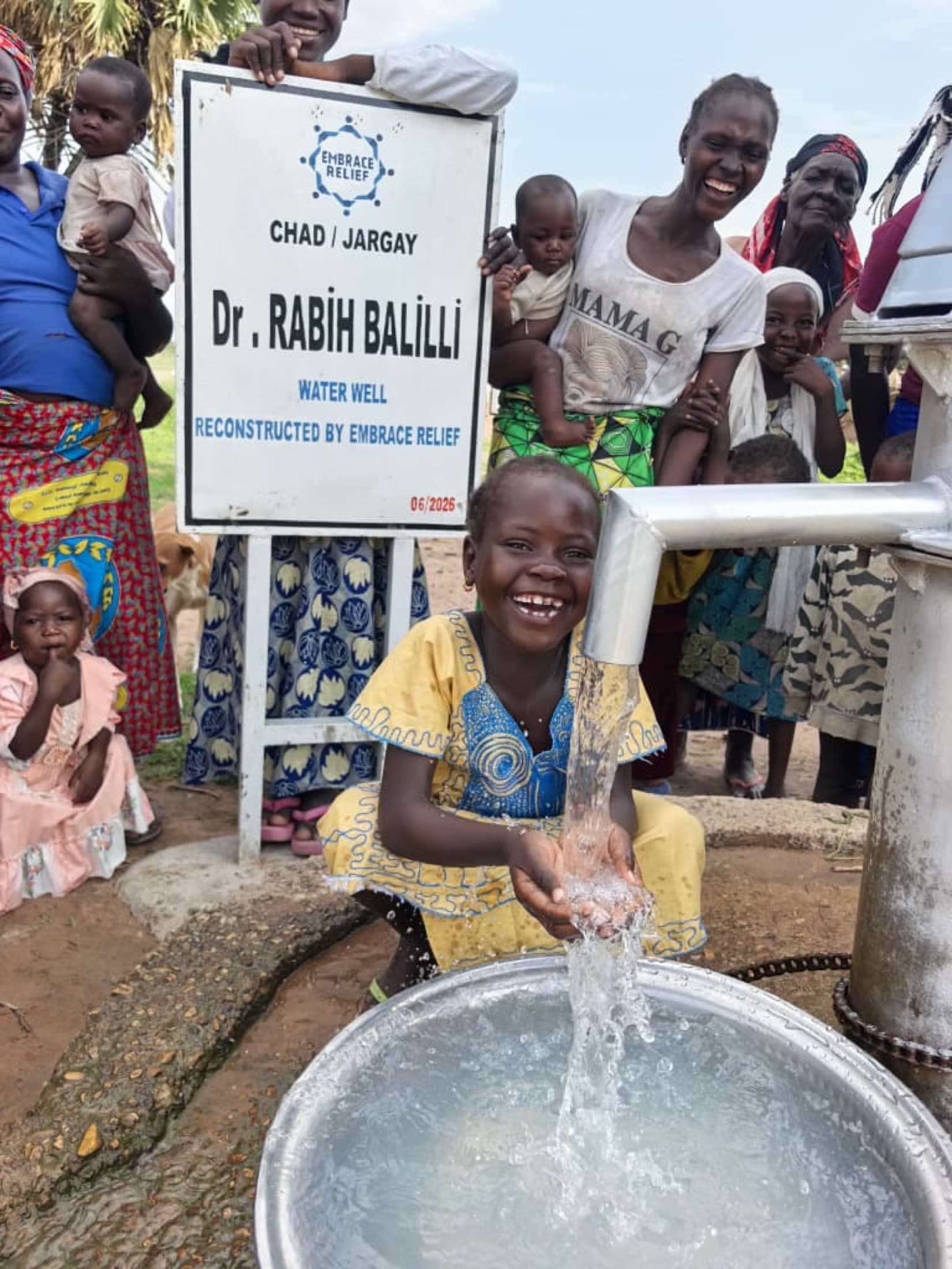 A family celebrating a reconstructed Embrace Relief water well