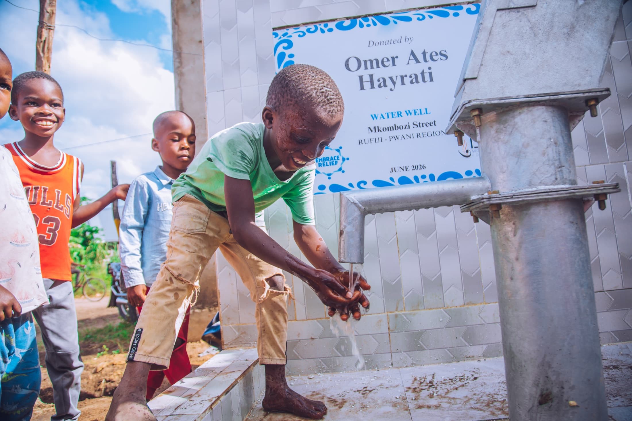 Child collecting water from a completed community well