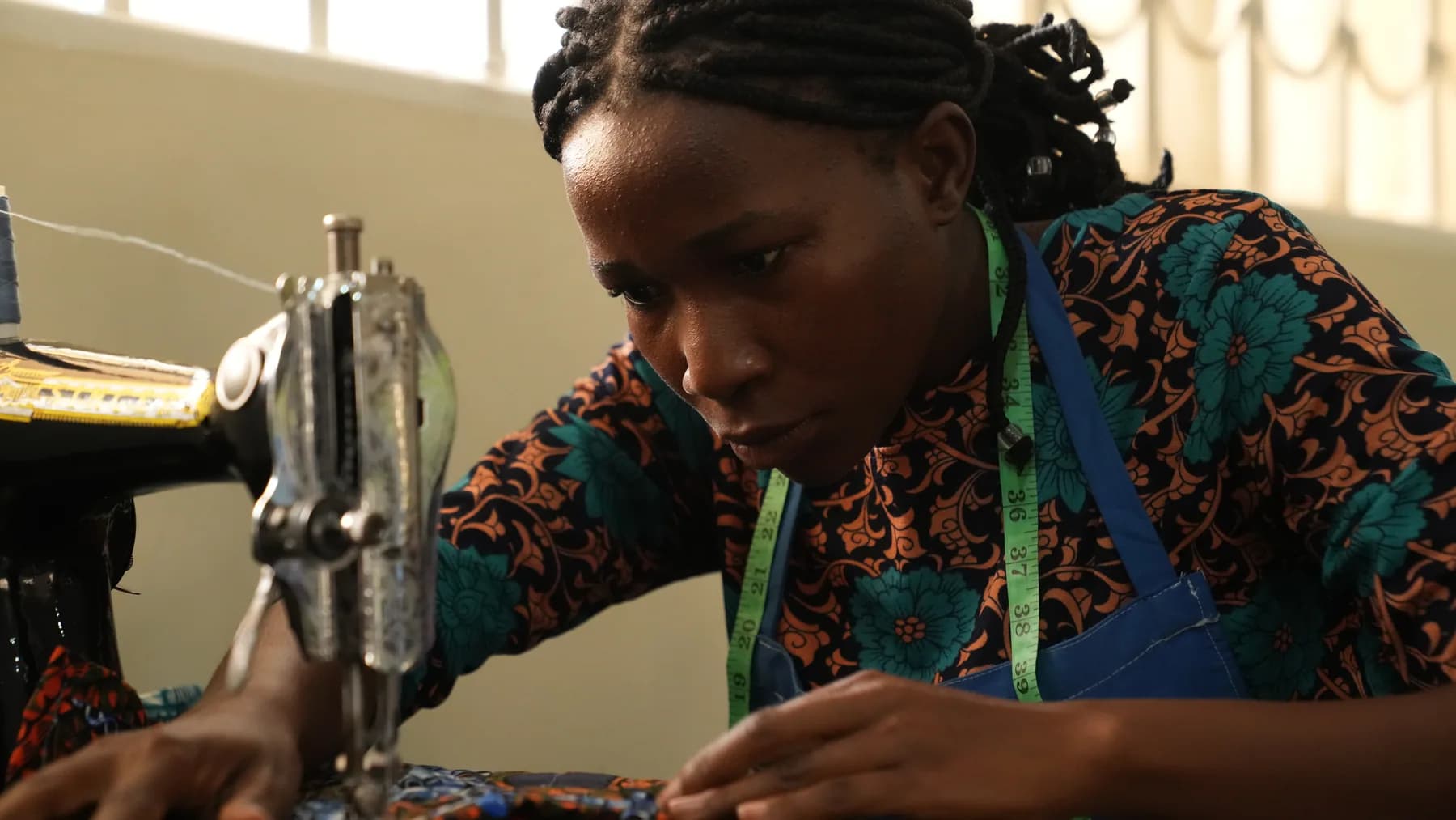 A woman working at a sewing machine during skills training
