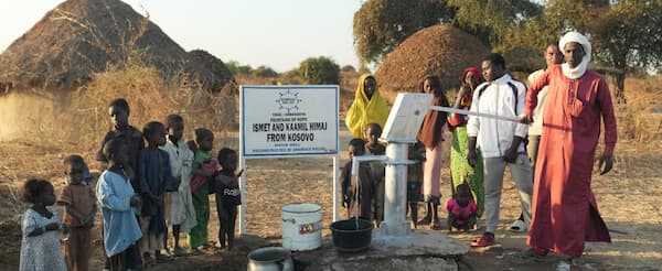 Community members gathering around a newly built water well