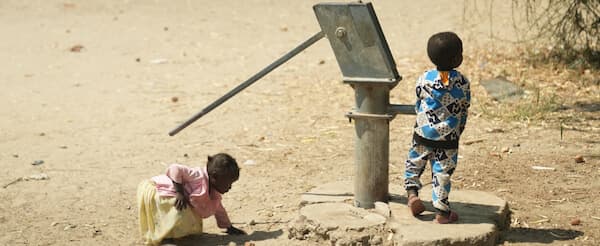 Children collecting water from a reconstructed community well