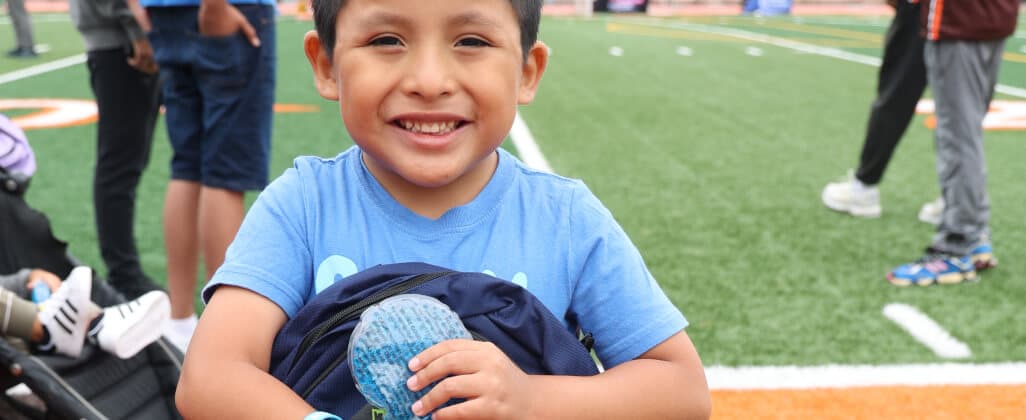 A child holding a filled school backpack