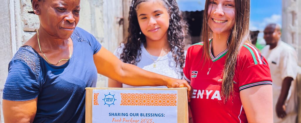 A family receiving an Embrace Relief food package