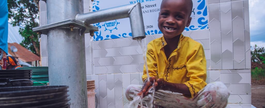 A child washing with clean water from a community well