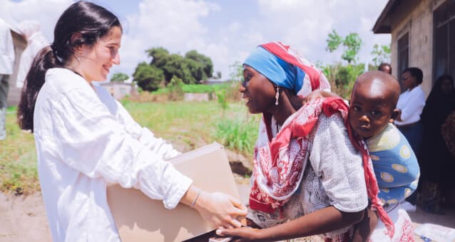 A volunteer delivering support to a mother and child