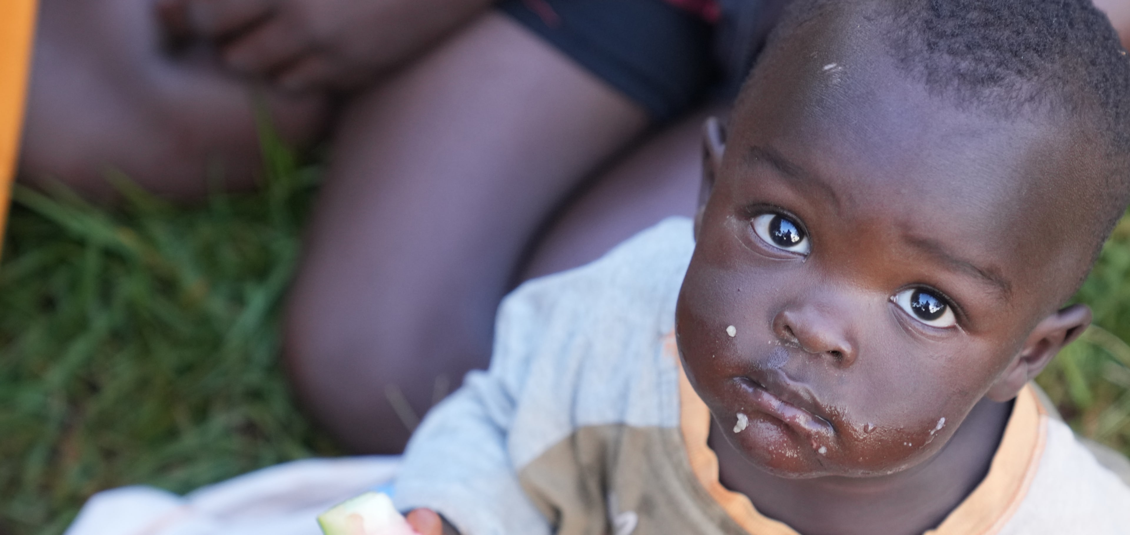A child looking towards the camera during a meal