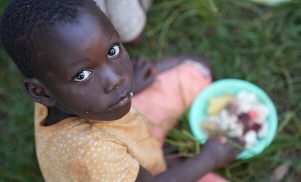 An orphaned child receiving a meal