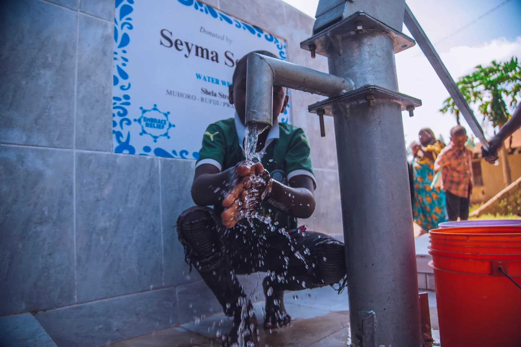 A child using clean water at a community well