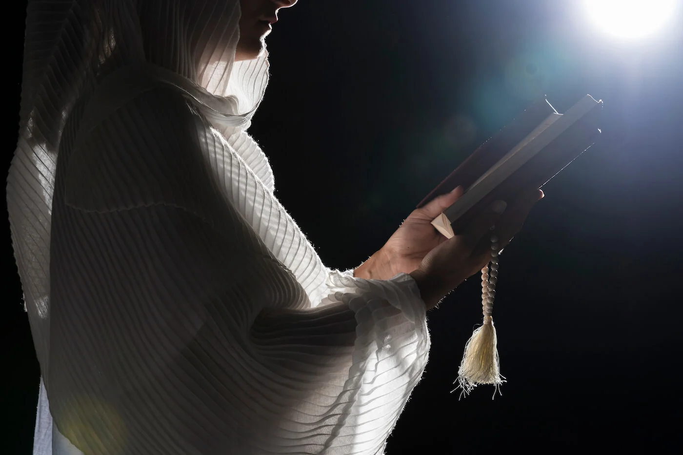 Woman praying under full moon representing spiritual devotion in Ramadan history