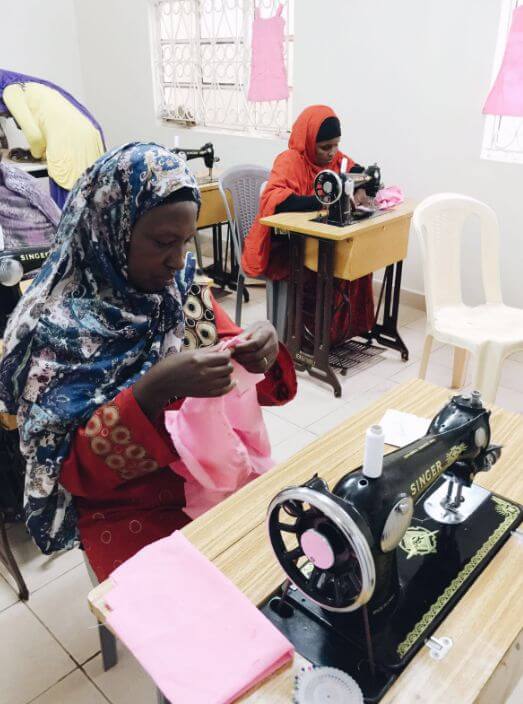 Woman using a sewing machine in the K.E.E.N. program