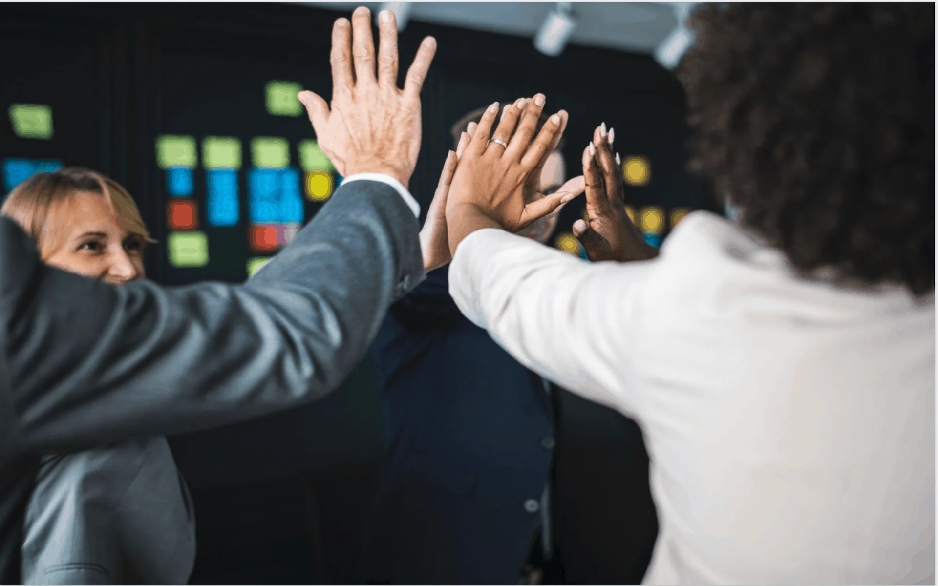 Business colleagues giving high five representing employee engagement and corporate teamwork