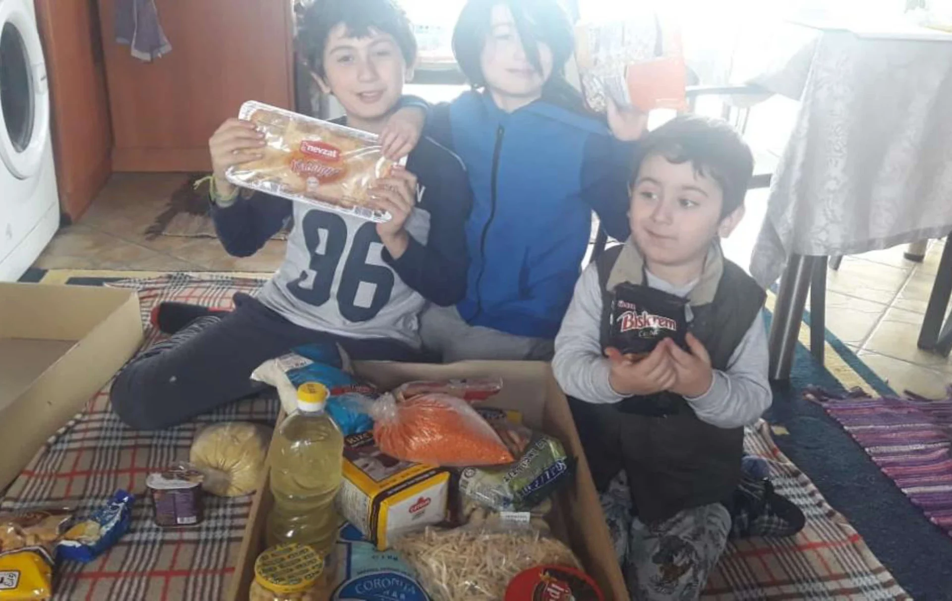 Refugee children in Greece receiving food packs from Embrace Relief volunteers