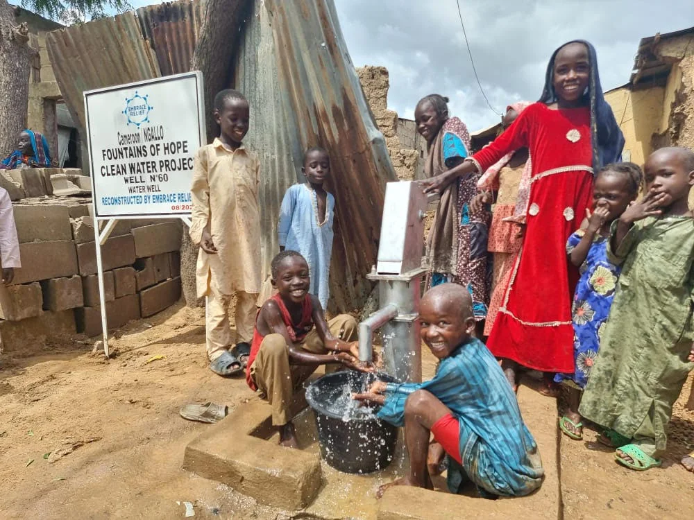 Community members accessing clean water from a rehabilitated well