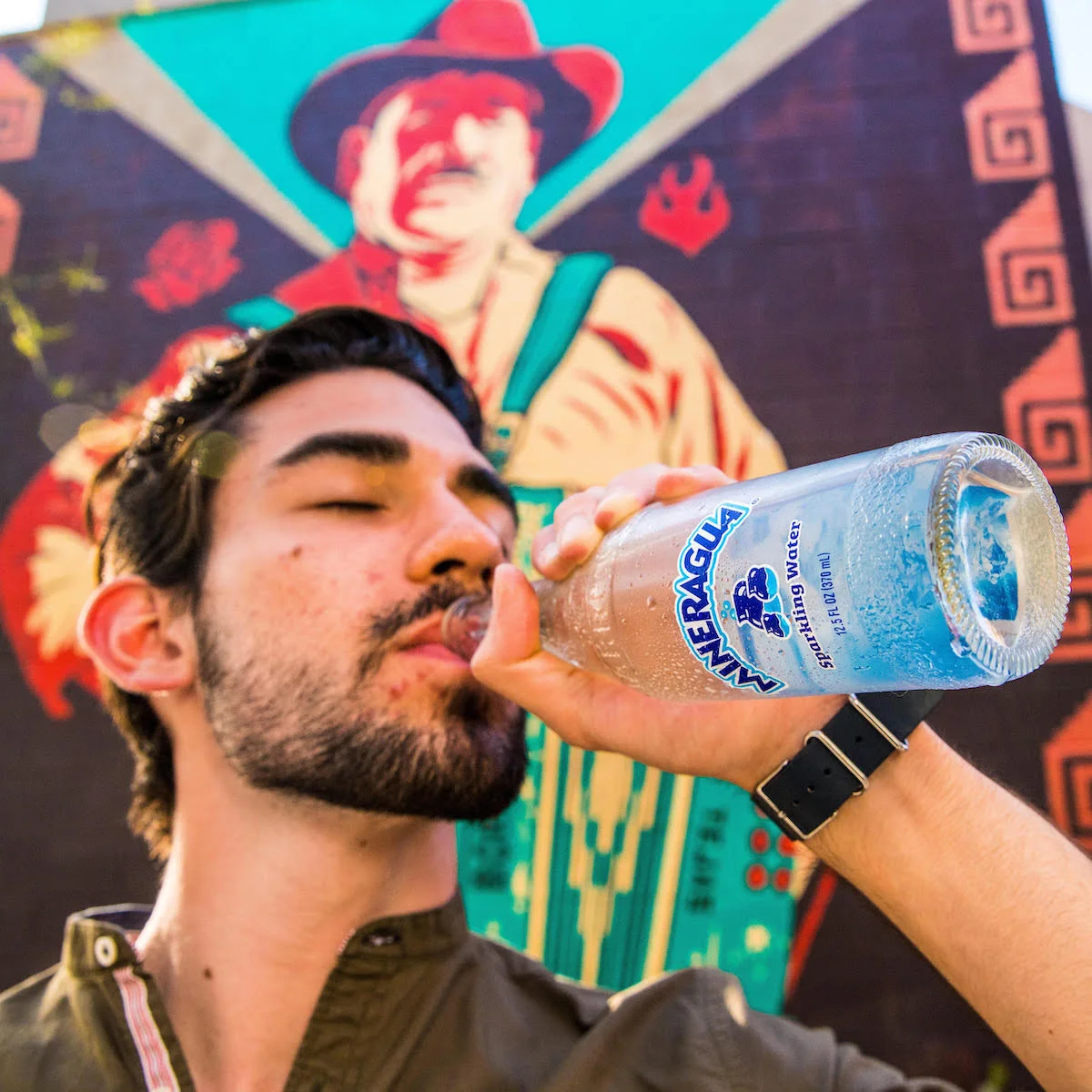 Person drinking water outdoors in hot weather