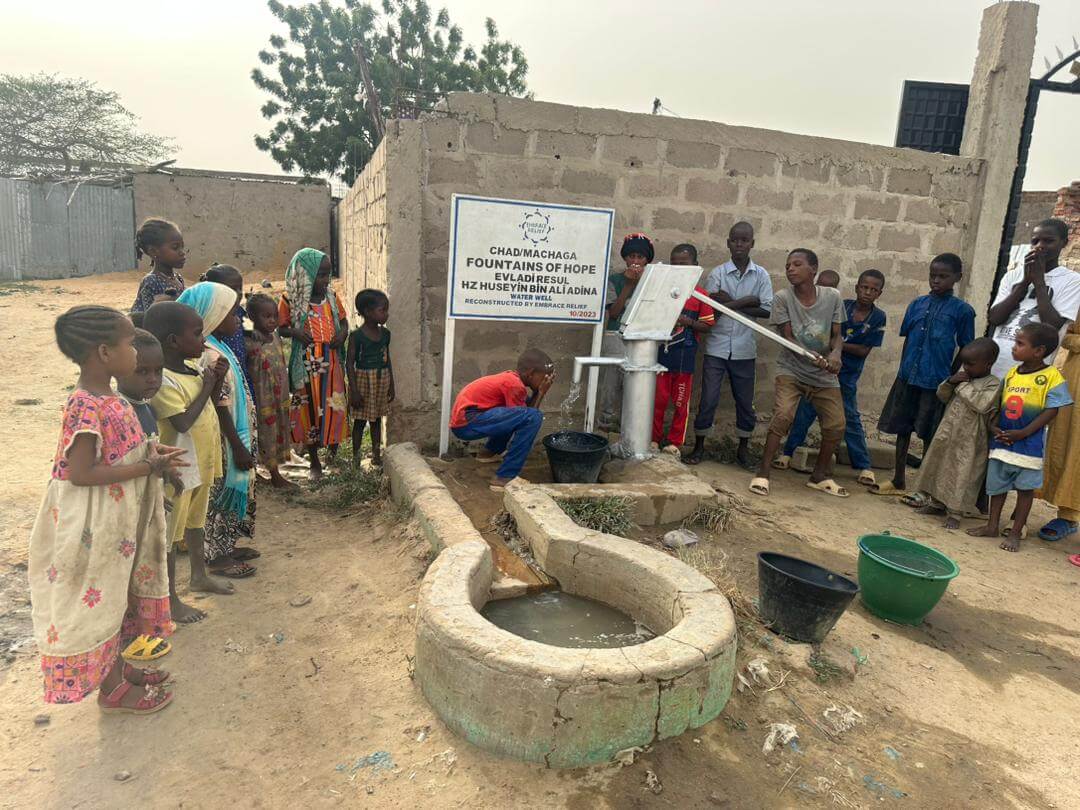 Community members accessing clean water from a well in Africa